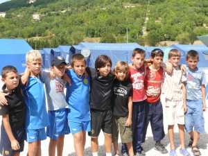 foto di gruppo tra bambini di roma e arischia nella tendopoli